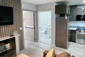 a kitchen with a refrigerator and a stove top oven at Peaceful Midtown Apartment with Gym and Parking in Tulsa