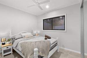 a white bedroom with a white bed and a window at Modern Haven in Toronto
