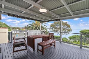 a wooden deck with a table and two chairs at Lakeshore Retreat in Toukley