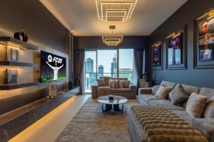 a living room with a couch and a tv at Luxury 1-Bedroom, High-Floor, Skyline Views in Dubai