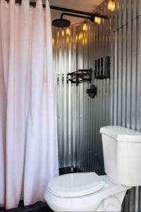 Un baño con inodoro y cortina de ducha. en Cozy Tiny Home At Private Moab Ranch, en Moab
