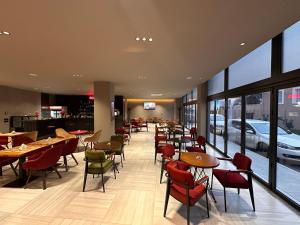 a restaurant with tables and chairs and windows at The Roots Boutique Hotel in Shkodër