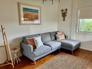 a living room with a gray couch and a window at LONGUSTINE - Pet Friendly in Robe +24 photos