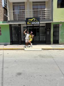 Zwei Personen sitzen auf dem Bürgersteig vor einem Gebäude in der Unterkunft Hotel Eli House in Nazca + 15 Fotos