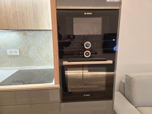 einen schwarzen Ofen in einer Küche mit Sofa in der Unterkunft Caparica Luxury Apartment by HOST-POINT in Costa da Caparica