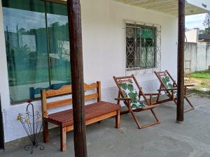two wooden benches sitting on the porch of a house at Recanto da Totoquinha in Juiz de Fora