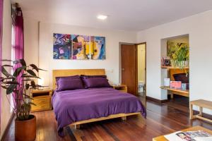 a bedroom with a bed with purple bedspread at Hotel Casa Deco in Bogotá +75 photos