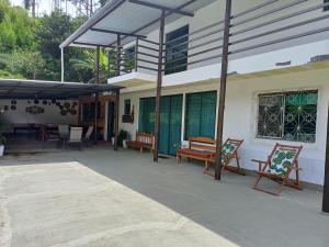 d'une terrasse avec des bancs, une table et des chaises. dans l'établissement Recanto da Totoquinha, à Juiz de Fora