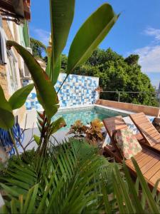 a swimming pool with two chairs and a table at Casa da Carmen e do Fernando in Rio de Janeiro