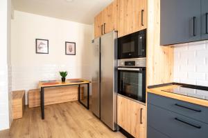 a kitchen with a refrigerator and a table at Suit Centrum in Santander +19 photos