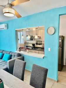 Una cocina con paredes azules y una mesa y sillas. en Departamento Zona Diamante, en Barra Vieja