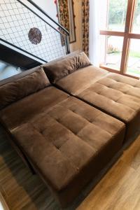 a brown leather couch sitting in a living room at Pousada Chalés do Vale - Vale dos Vinhedos in Bento Gonçalves
