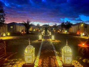 a street with lights in the middle of a city at Camel Experience Camp in Merzouga