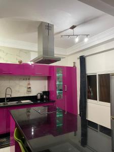 uma cozinha com armários cor-de-rosa e um balcão em Marrakech héberg em Marraquexe