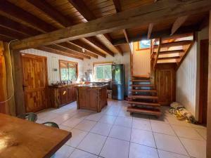 a kitchen with wooden cabinets and a staircase in it at Cheerful Santa Juana Cabin in Santa Juana