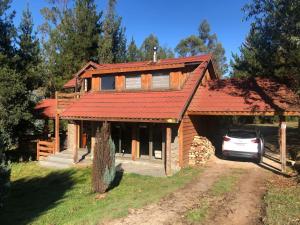 a house with a car parked in front of it at Cheerful Santa Juana Cabin in Santa Juana +24 photos