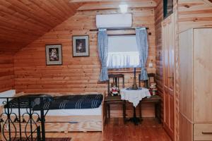 a bedroom in a log cabin with a window at Holiday house with a swimming pool Gospic, Velebit - 21753 in Gospić