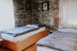 a bedroom with two beds and a brick wall at Holiday house with a swimming pool Gospic, Velebit - 21753 in Gospić