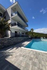 a house with a swimming pool in front of a building at Family friendly house with a swimming pool Opatija - 23833 in Matulji