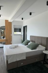 a bedroom with a large bed with white sheets and green pillows at Family friendly house with a swimming pool Opatija - 23833 in Matulji +20 photos