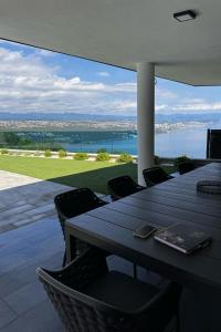 a table on a patio with a view of the water at Family friendly house with a swimming pool Opatija - 23833 in Matulji