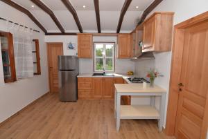 a kitchen with wooden cabinets and a refrigerator at Secluded fisherman's cottage Cove Zizanj, Pasman - 23925 in Tkon +9 photos