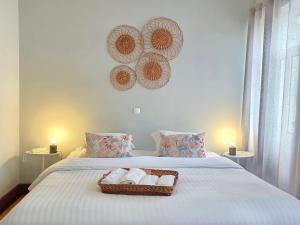 a bedroom with a bed with a basket of towels at ASPA Studios - Urban Conscious Living in Funchal