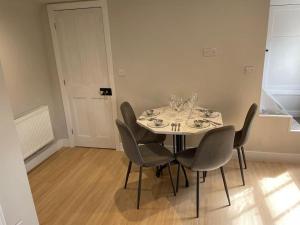 a dining room with a table and four chairs at The Lodge in Wadhurst