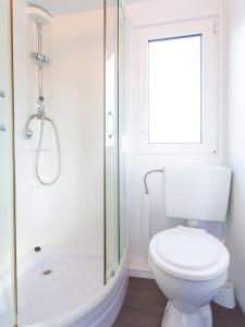 a white bathroom with a toilet and a shower at Zelena Laguna Mobile Homes in Poreč