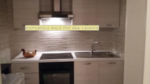 a kitchen with a sink and a sign on the wall at Dimora Dei Gelsi in Polignano a Mare