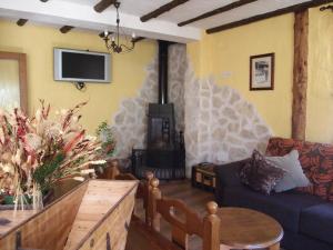 sala de estar con sofá y estufa de leña en Dulce Encanto del Valle, en Valle de Tabladillo