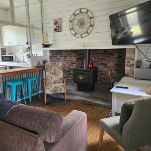 Una sala de estar con un sofá y una estufa. en Farm Stay Pepperina, en Kootingal