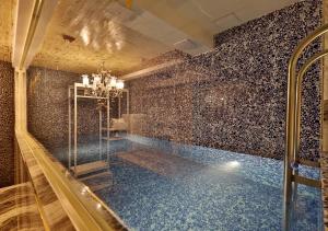 a bathroom with a swimming pool with a tile wall at February Hotel Gimhae in Gimhae
