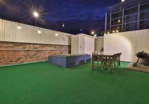 a patio with green flooring and a table and chairs at February Hotel Gimhae in Gimhae