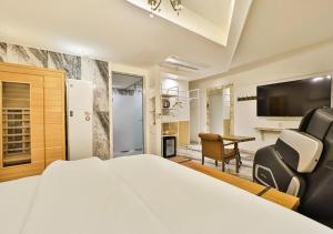a hotel room with a bed and a desk at February Hotel Gimhae in Gimhae
