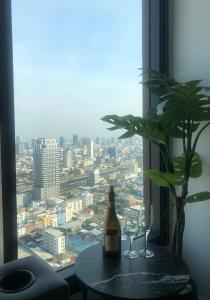 a bottle of wine and two glasses on a table with a window at Luxury condo in Bangkok,NearBTSMochit,MRTChatuchak in Bangkok