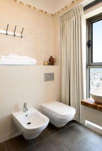 a bathroom with a white toilet and a sink at Lovely 3 Bedroom Mini Penthouse on 30th Floor in Netanya +15 photos
