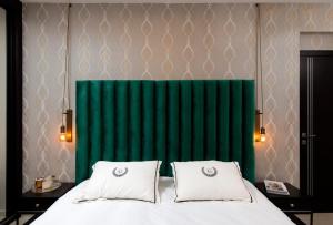 a bedroom with a green headboard and a bed with two pillows at Lovely 3 Bedroom Mini Penthouse on 30th Floor in Netanya