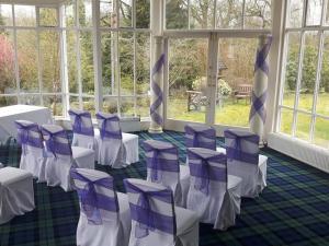 a room with purple and white chairs and windows at Kirkconnel Hall Hotel in Ecclefechan +4 photos
