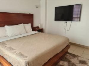 a bedroom with a bed and a flat screen tv at Skyline Dream Homes 4, 6 in Nairobi