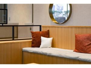 a bench with two pillows on it with a mirror at The One Five Fukuoka Tenjin - Vacation STAY 40121v in Fukuoka +27 photos