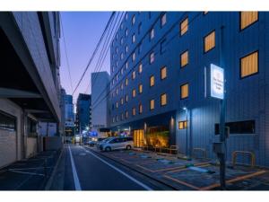 a white car parked next to a tall building at The One Five Fukuoka Tenjin - Vacation STAY 40121v in Fukuoka