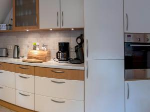 a kitchen with white cabinets and a white refrigerator at Ferienwohnung mit Terrasse, Bad Bodenteich in Häcklingen