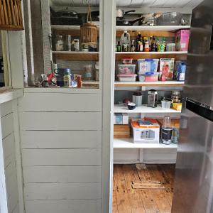a kitchen pantry with white walls and shelves at FarmStay Pepperina & Bird Sanctuary in Bendemeer