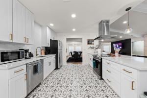 a kitchen with white cabinets and a tile floor at Spacious 6 Bed House Pet Friendly AFB in San Antonio