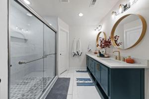 a bathroom with a shower and a sink and a mirror at Spacious 6 Bed House Pet Friendly AFB in San Antonio +30 photos