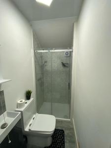 a bathroom with a shower and a toilet and a sink at Heathrow Close Comfort Room in Stanwell +3 photos