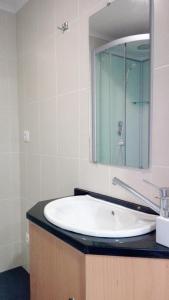 bagno con lavandino bianco e specchio di Quinta do Chico Feijão a Lajes