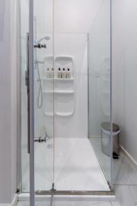a shower with a glass door in a bathroom at Grand 5-Bedroom Villa in Fendalton in Christchurch