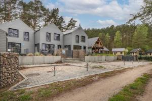a large house in the middle of a dirt road at Holiday Home by Lake Wise ka with Sauna in Wisełka